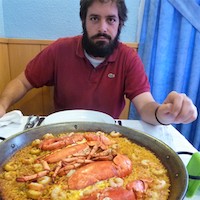 Travel guide Enrique with paella dish in front of him